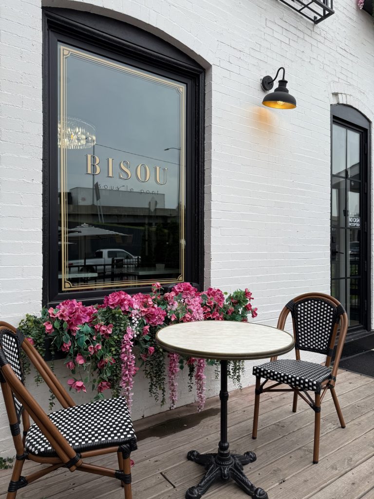 Bisou window with small table, chairs and flower box with pink flowers, Kansas City Coffee Shop