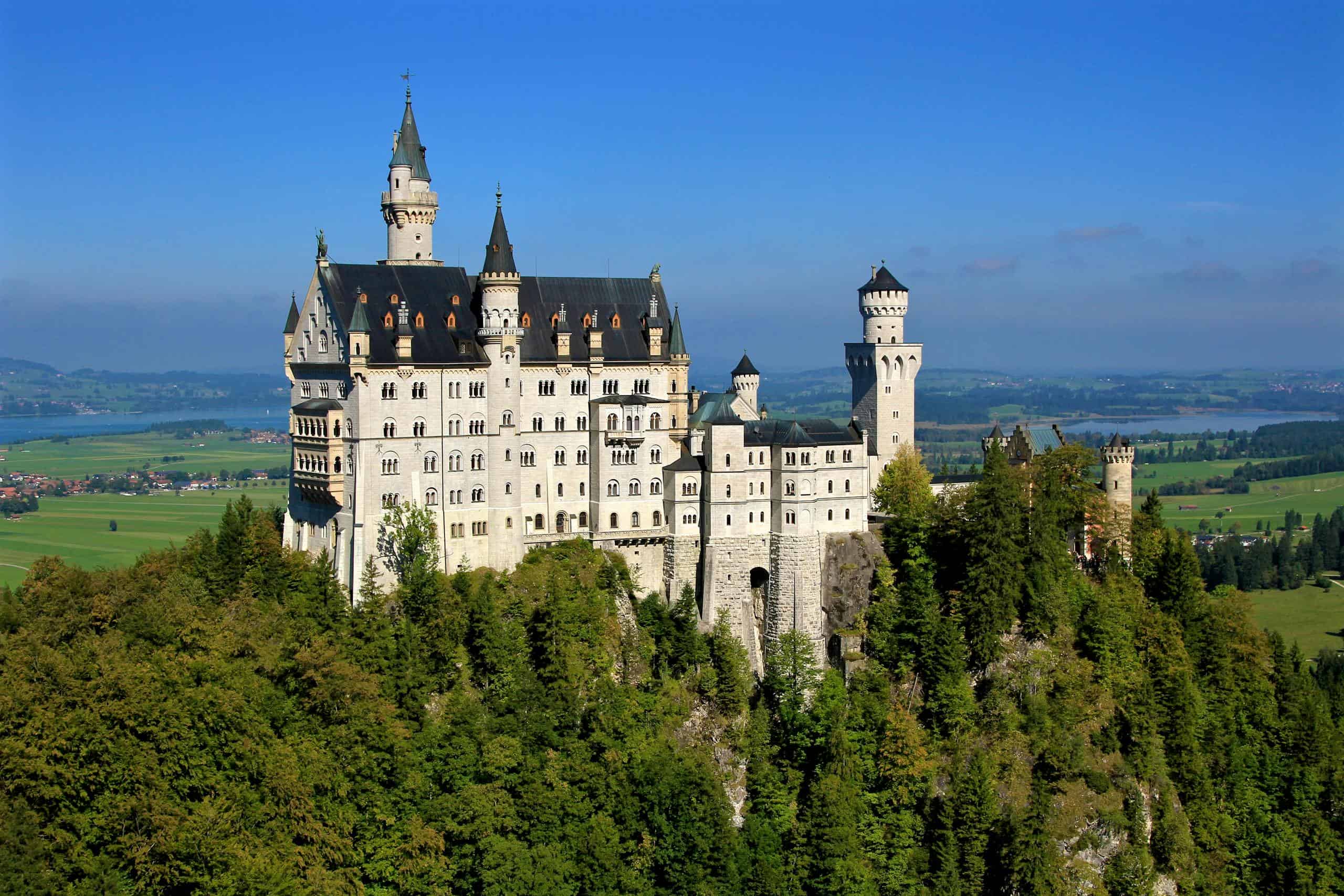 Aerial view of the iconic Neuschwanstein Castle surrounded by lush greenery in Bavaria, Germany.