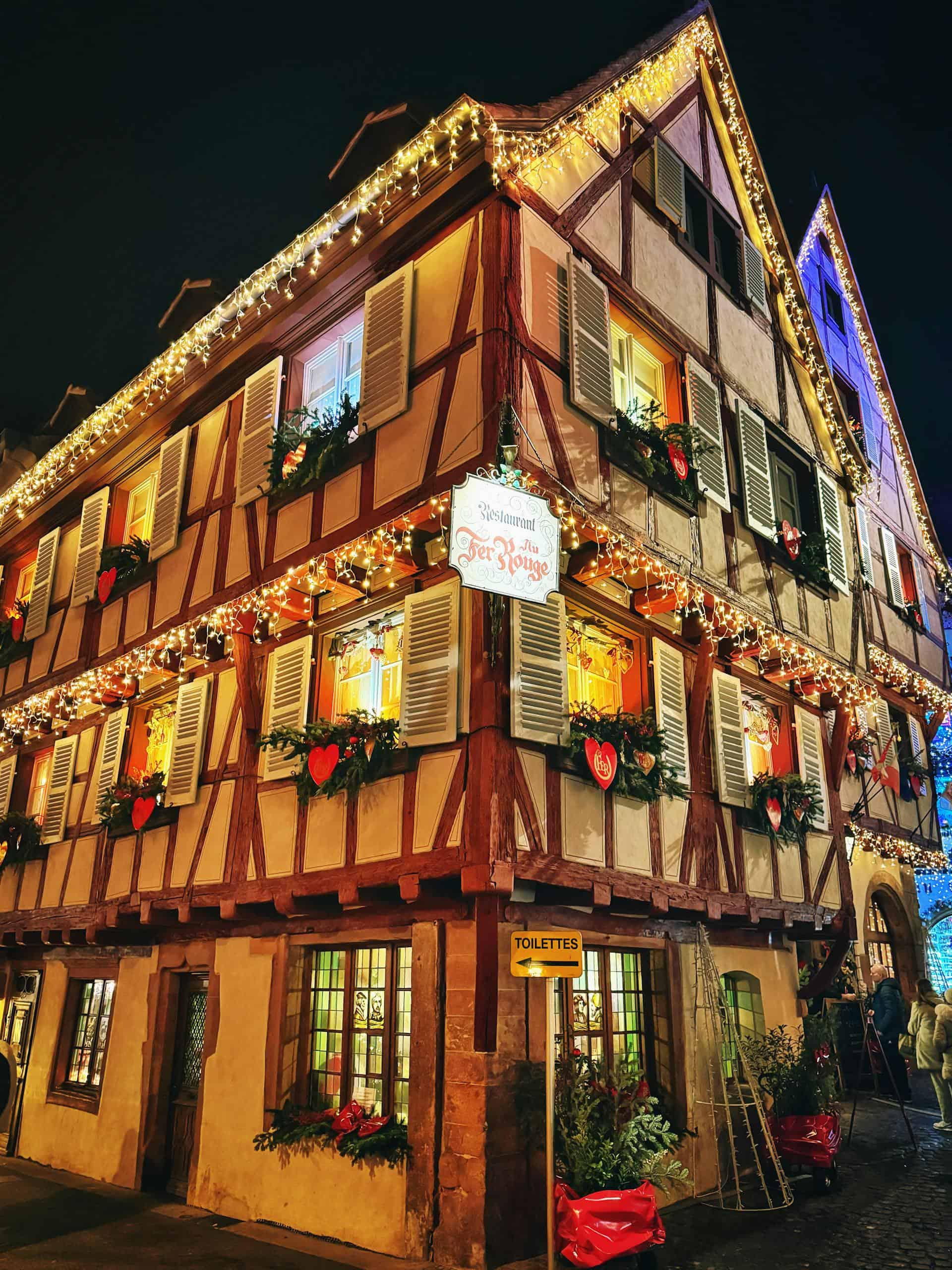 Beautifully decorated traditional European house with Christmas lights at night.