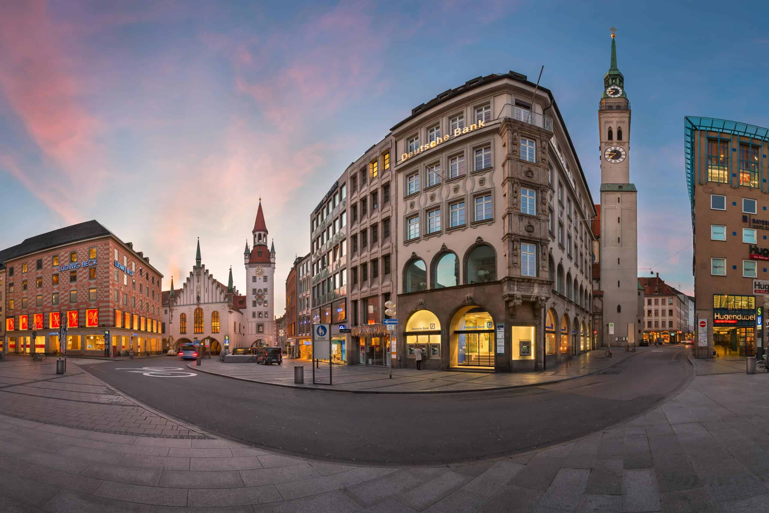 Panoramic view of Marienplatz in Munich, Germany, showcasing historic buildings and a clock tower at dusk.