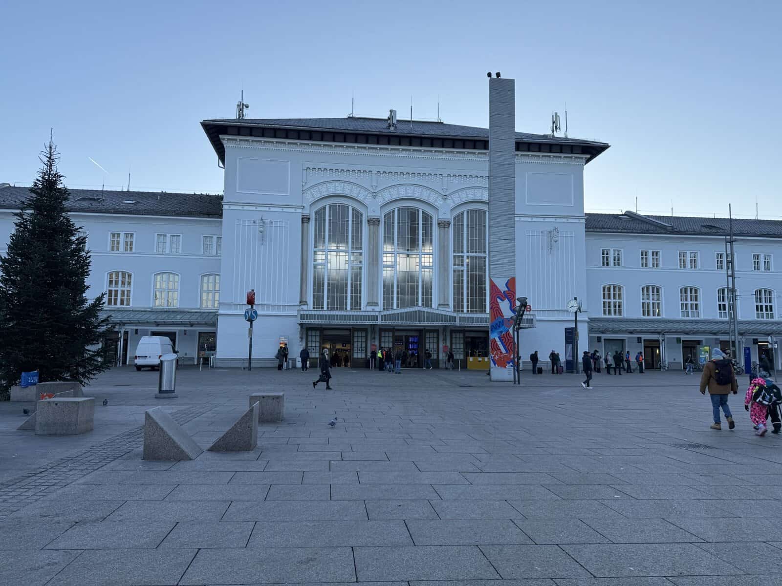 Salzburg Hauptbahnhof exterior with travelers walking outside the main entrance of Salzburg train station in Austria