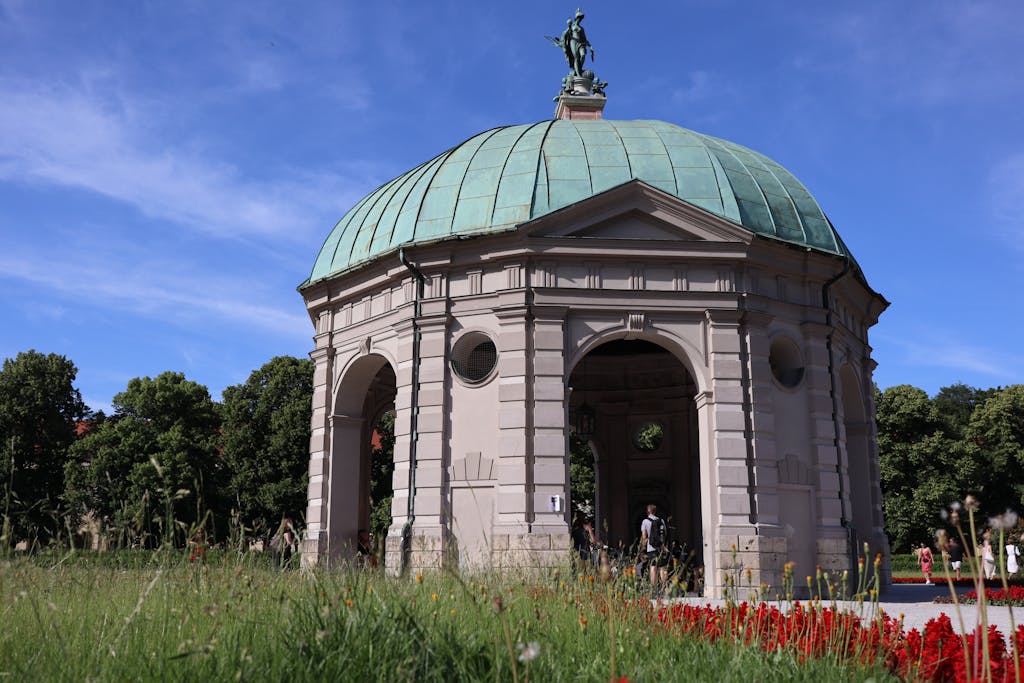 Diana Temple in Hofgarten, Munich with clear blue sky and flowers in front
