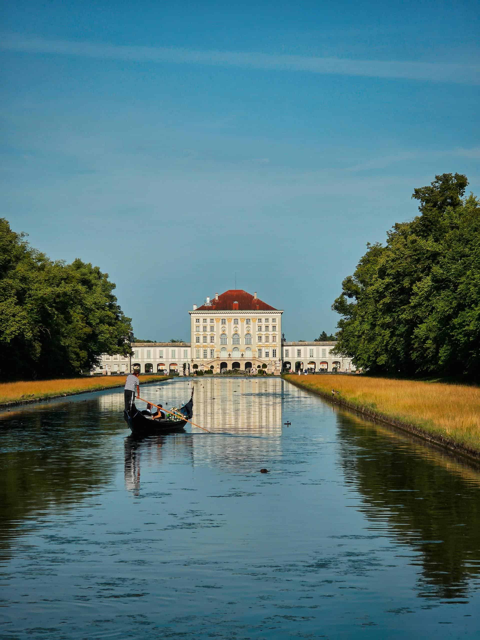 Gondola in front of Nymphenburg Palace, Munich, Germany, reflecting in a serene canal.