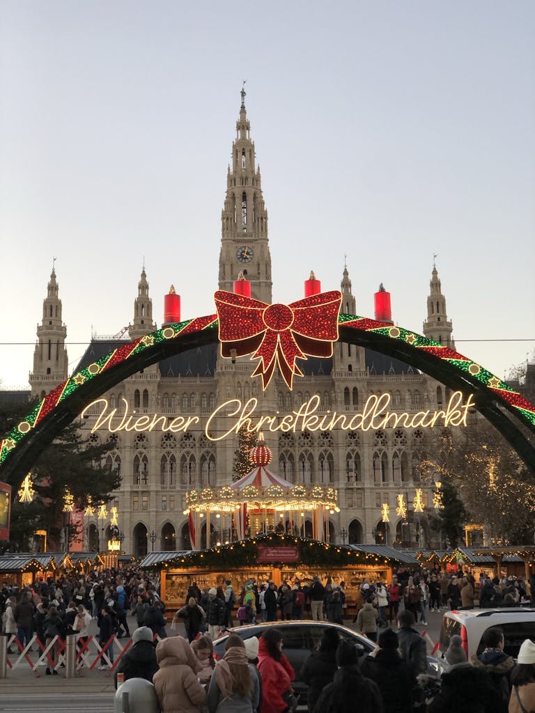 Festive Vienna Christmas Market bustling with visitors under city hall's grandeur.