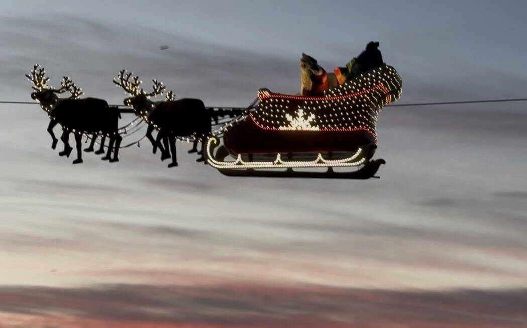 Flying Santa crossing Lake Geneva above the Montreux Christmas Market with mountains in the background