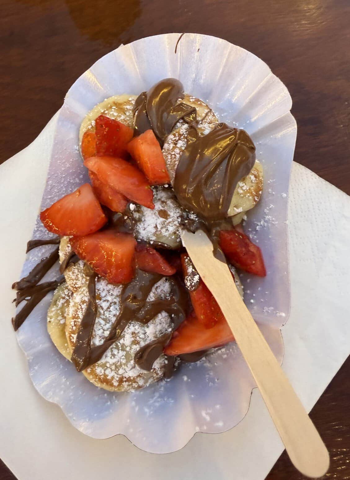 Christmas Market Mini pancakes topped with Strawberries, Nutella, and powered sugar