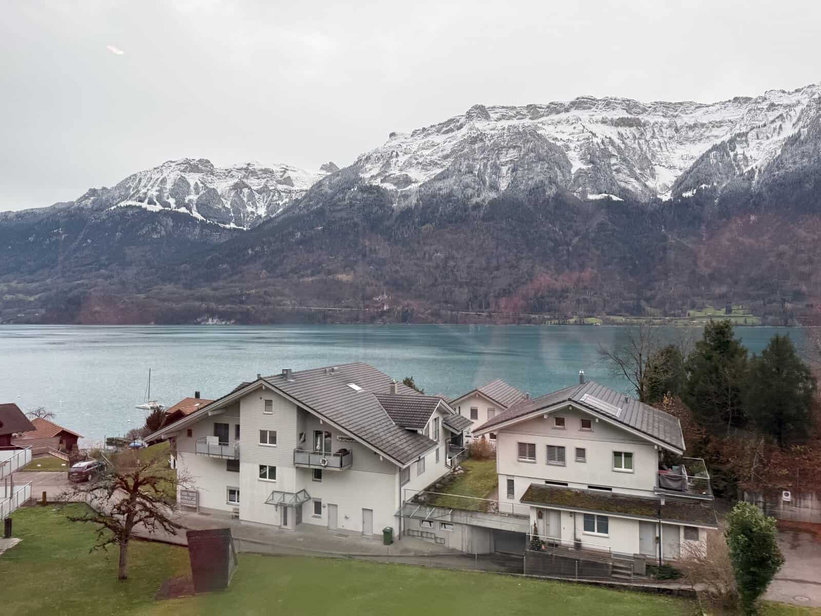 Lake and snow-capped mountains viewed from a panoramic train window in Switzerland on a day trip from Zurich