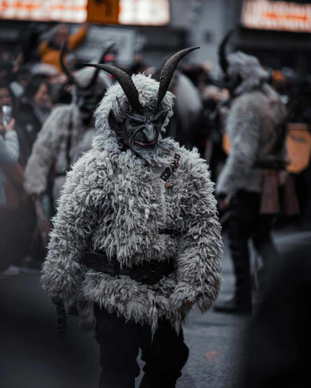 Participants in Krampus costumes parade through Munich, celebrating Bavarian culture.