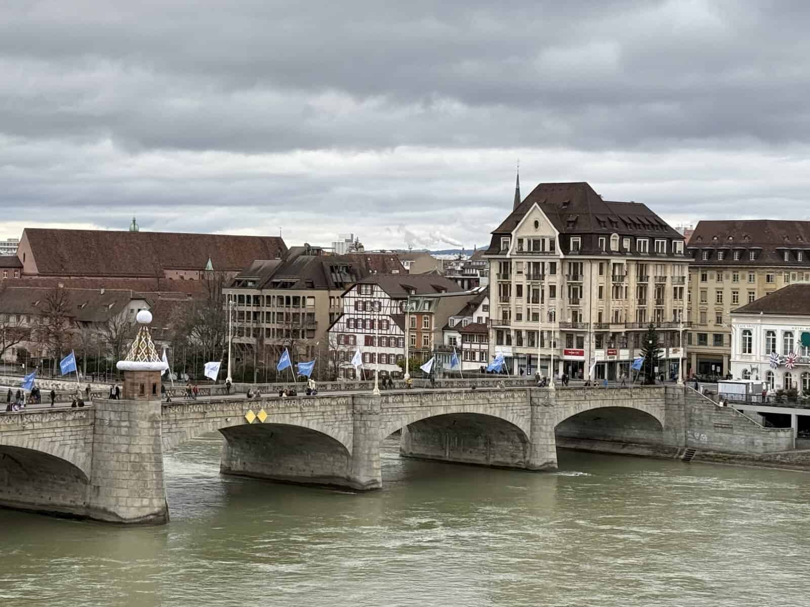 Colorful historic buildings along the Rhine River in Basel, Switzerland under cloudy winter skies