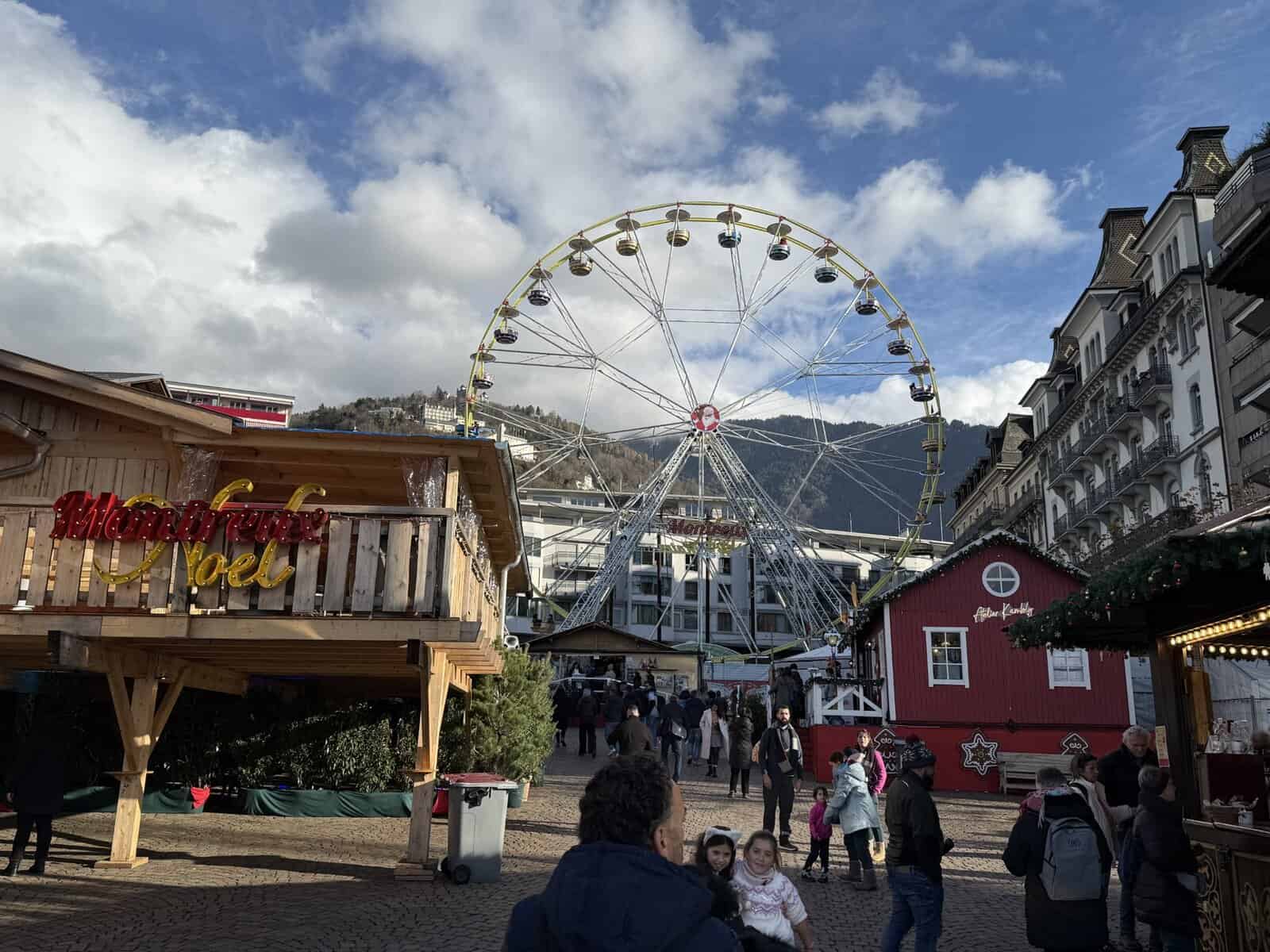 Ferris wheel at the Montreux Christmas Market surrounded by festive chalets and alpine scenery