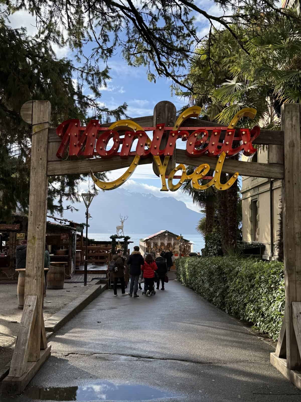 Montreux Noël Christmas Market entrance sign with Lake Geneva and mountain views behind