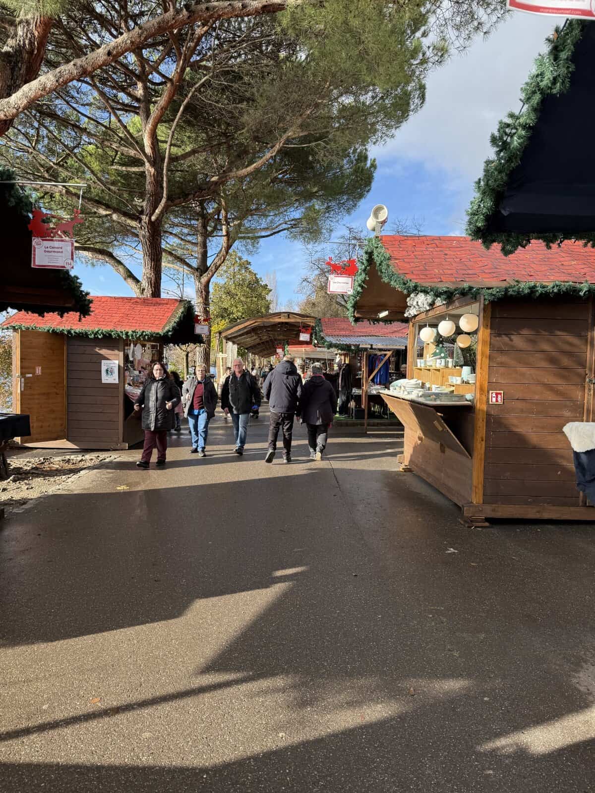 Visitors walking through wooden chalet stalls at the Montreux Christmas Market in winter