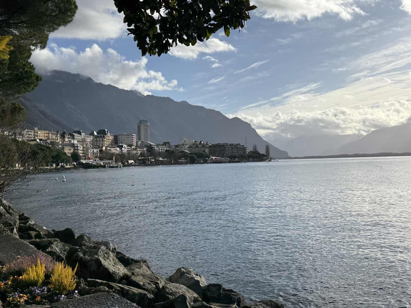Lake Geneva shoreline in Montreux with Christmas market lights and mountains in the distance