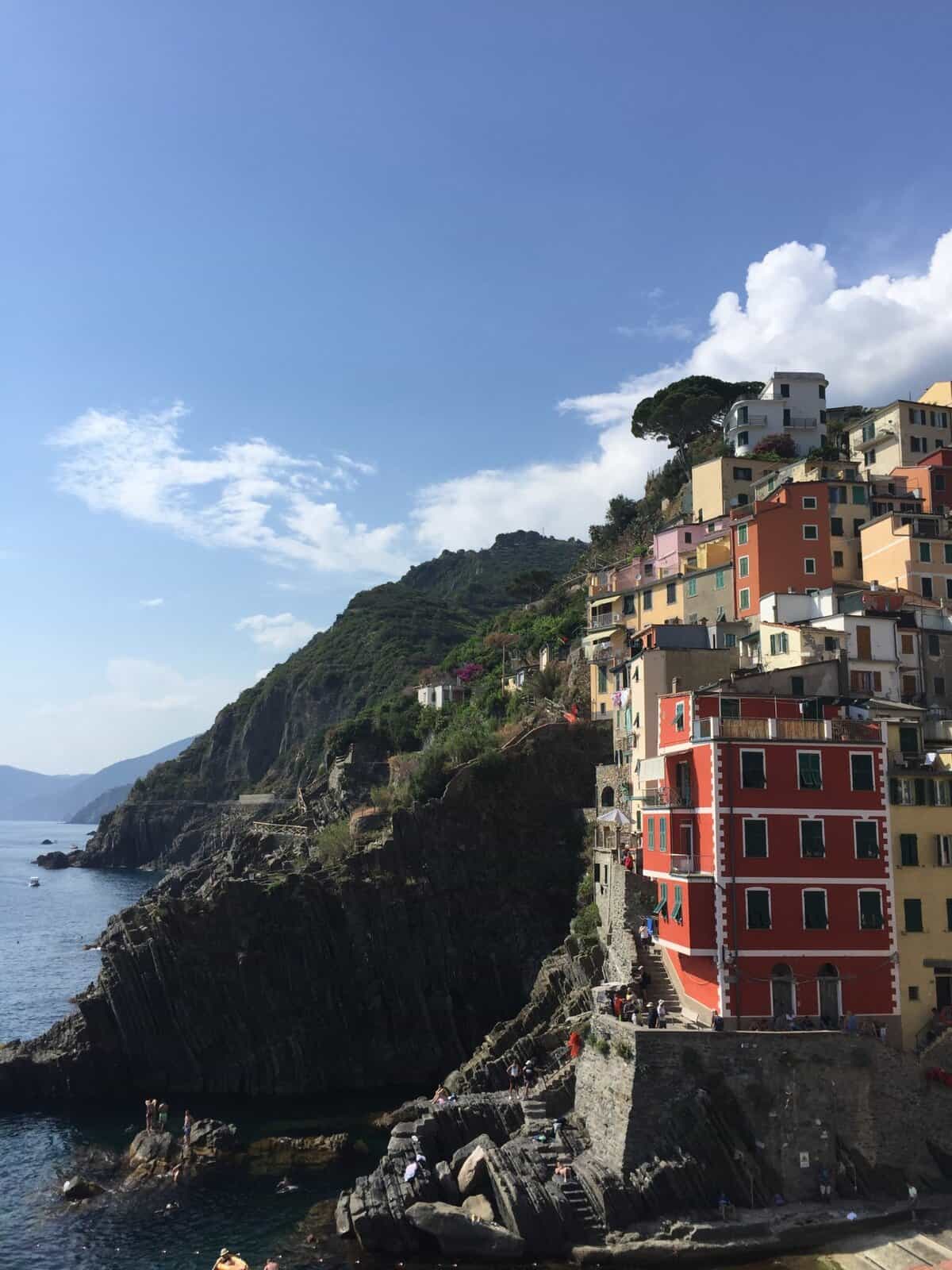 Riomaggiore in Cinque Terre Italy with pastel houses perched on dramatic cliffs above the sea