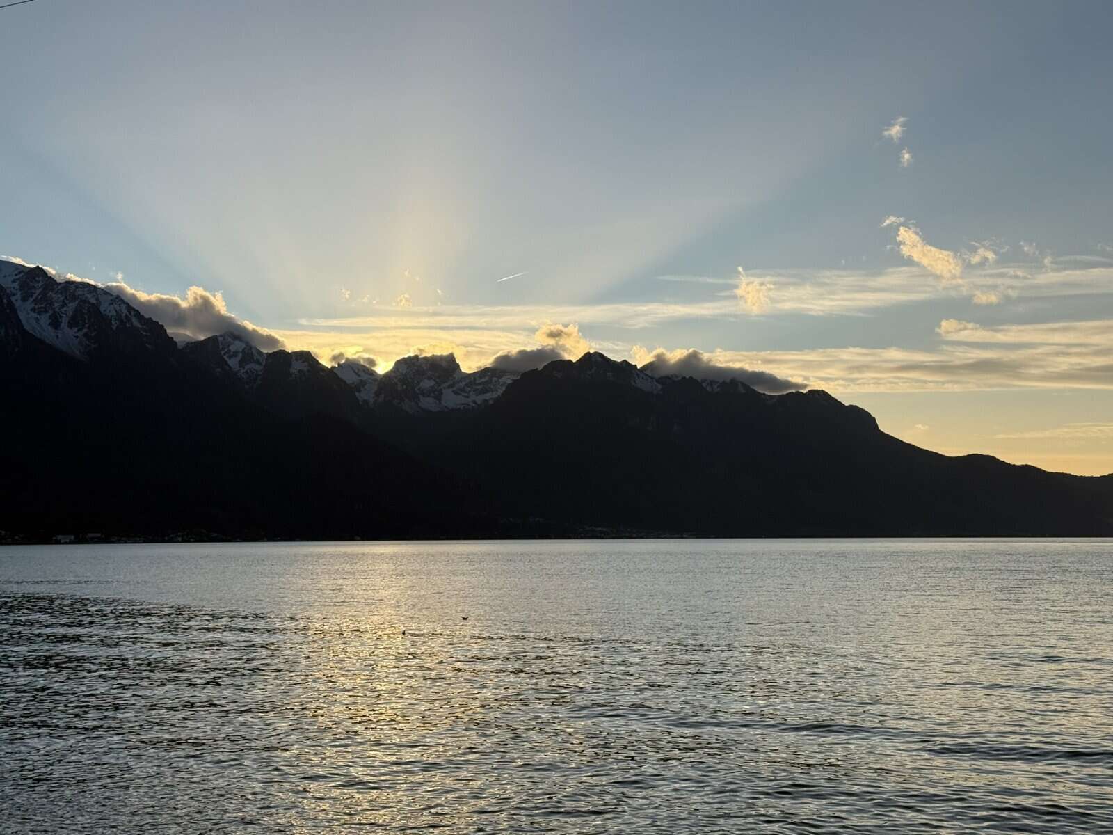 Sunset over Lake Geneva with snow capped Alps behind Montreux in winter