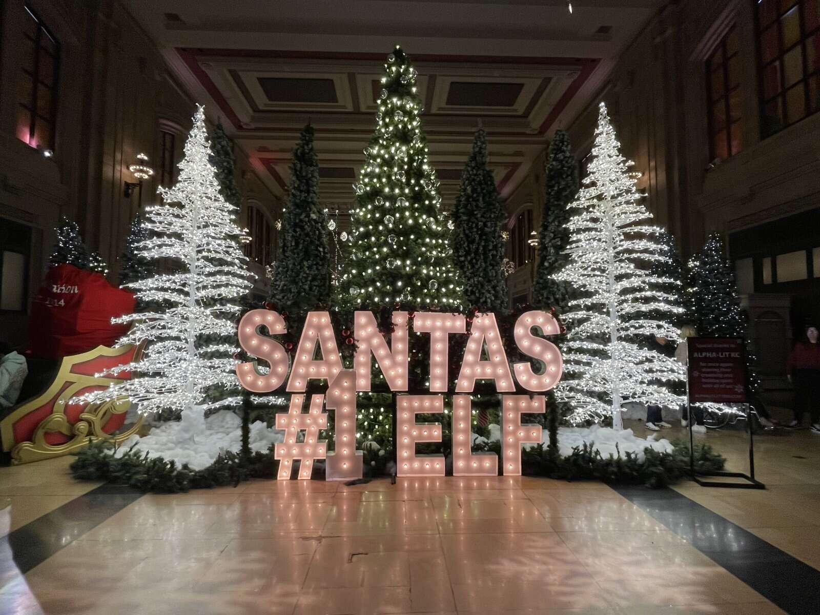 Holiday Reflections display inside Union Station Kansas City featuring Santa’s #1 Elf sign and glowing Christmas trees