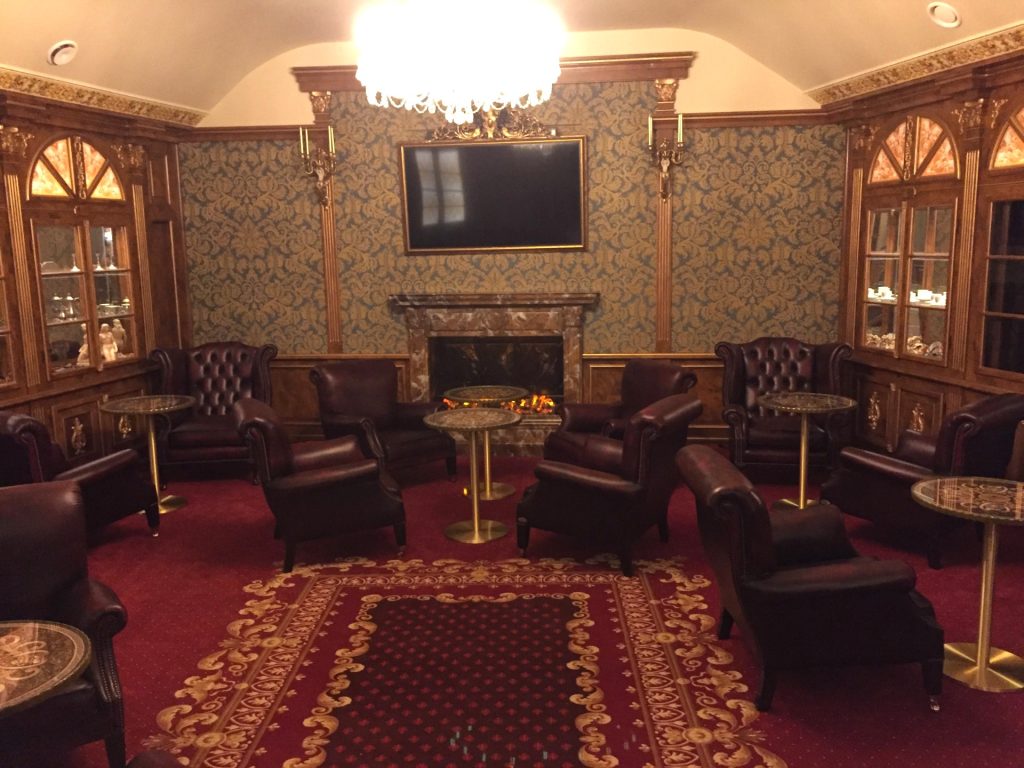 Elegant hotel lounge with leather chairs and fireplace in Prague.