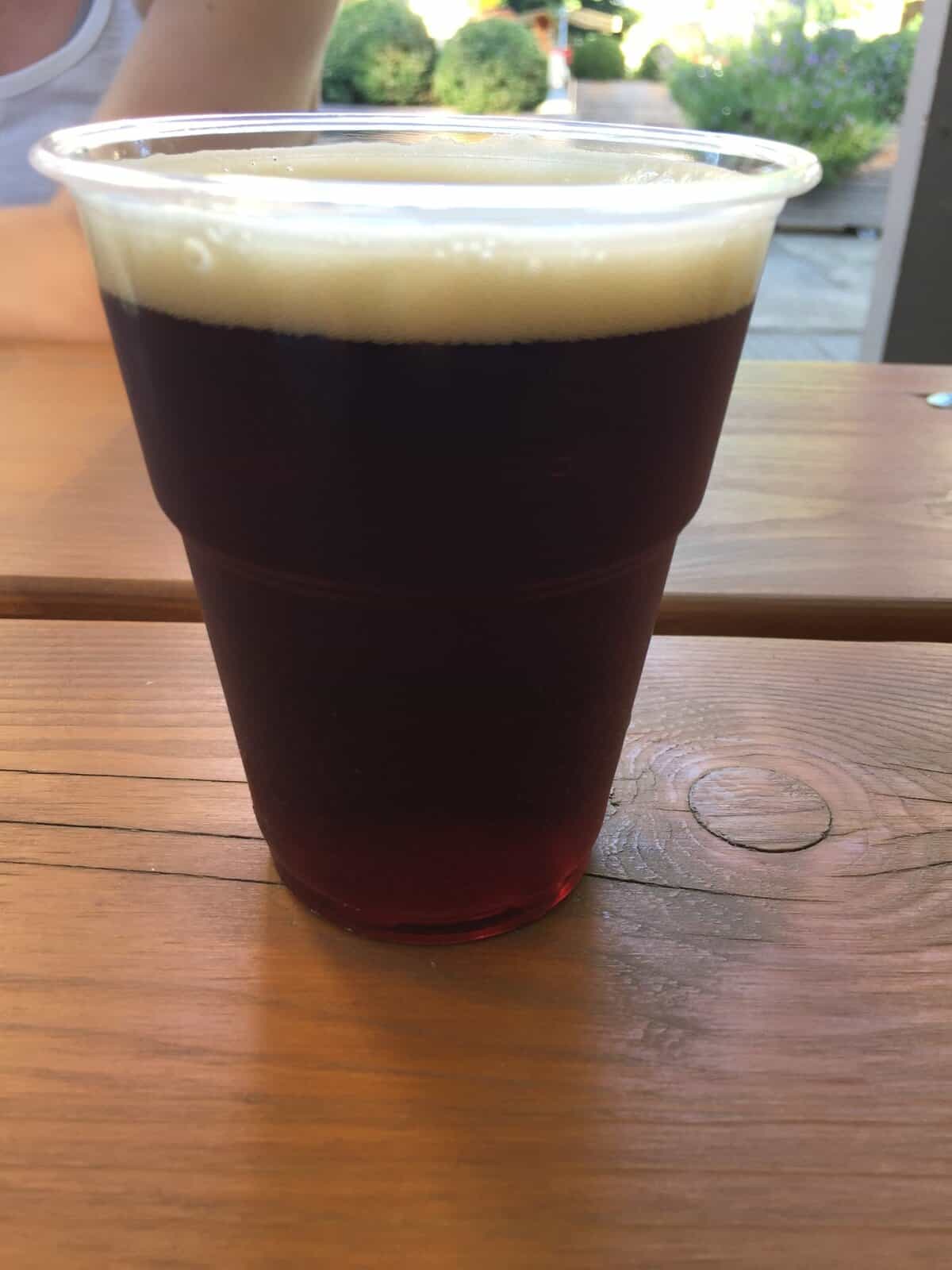 Dark Czech beer in a plastic cup at Letná Beer Garden in Letná Park overlooking Prague.