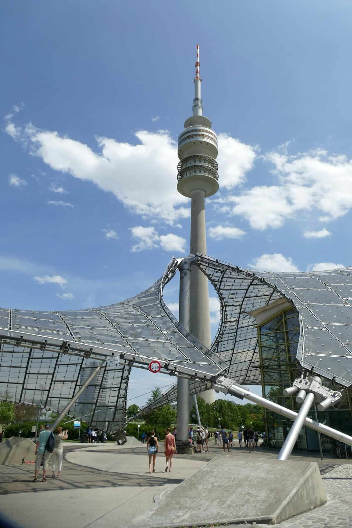 The Olympiaturm in Munich with modern architectural elements under a clear blue sky.
