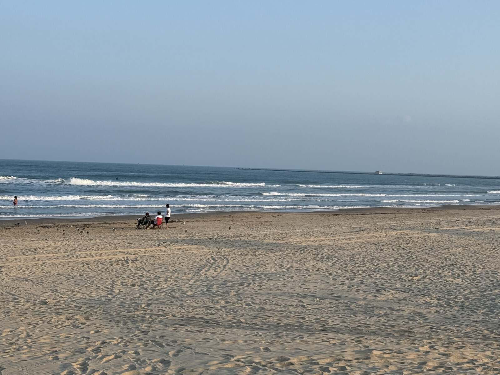 Isla Blanca beach in South Padre Island with waves and people relaxing on the sand