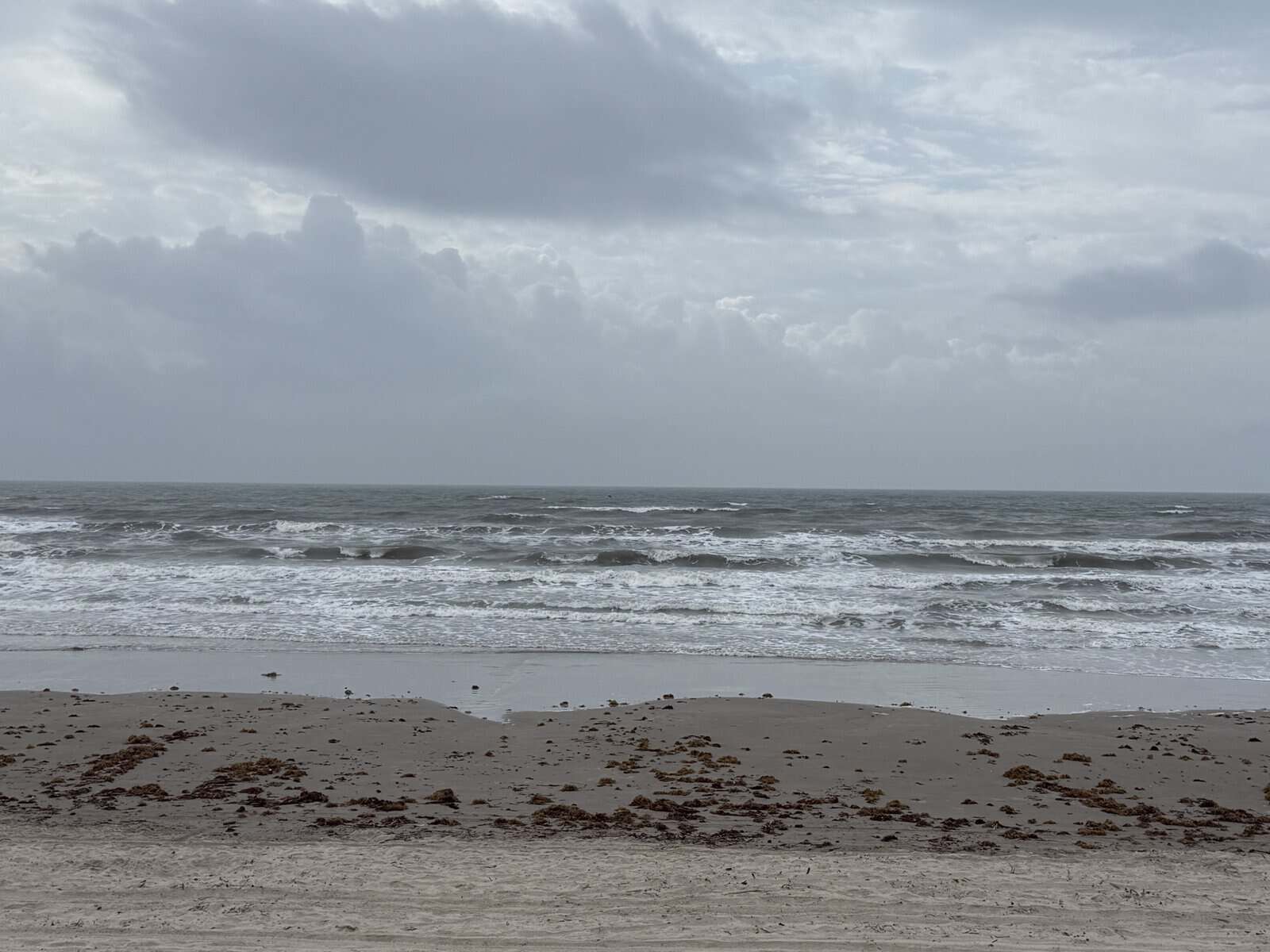 Galveston beach with waves and cloudy skies along the Gulf Coast