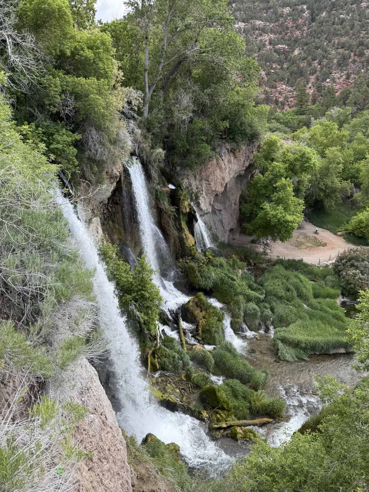 Overlook view of Rifle Falls State Park waterfall cascading into a lush canyon in Colorado
