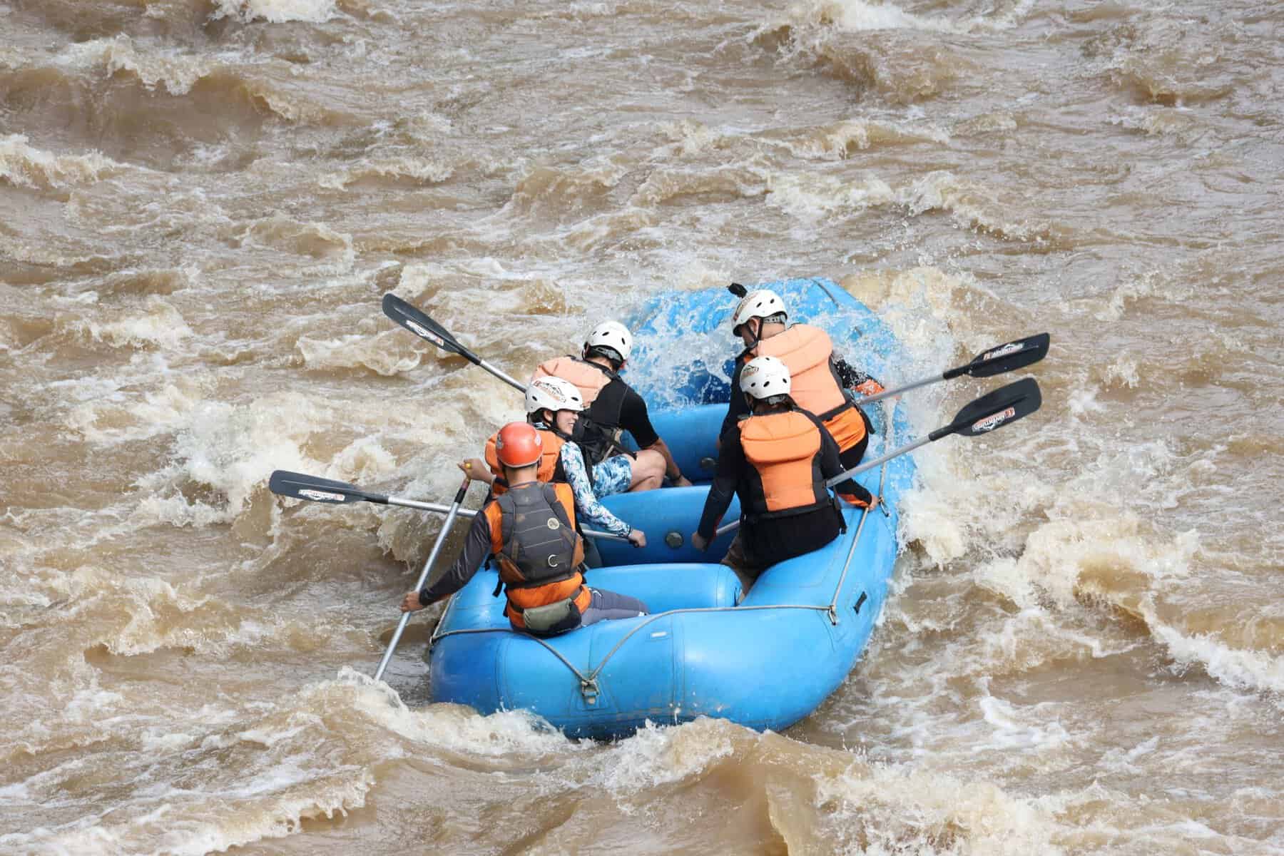Exciting white water rafting experience with group navigating rapids in inflatable raft.