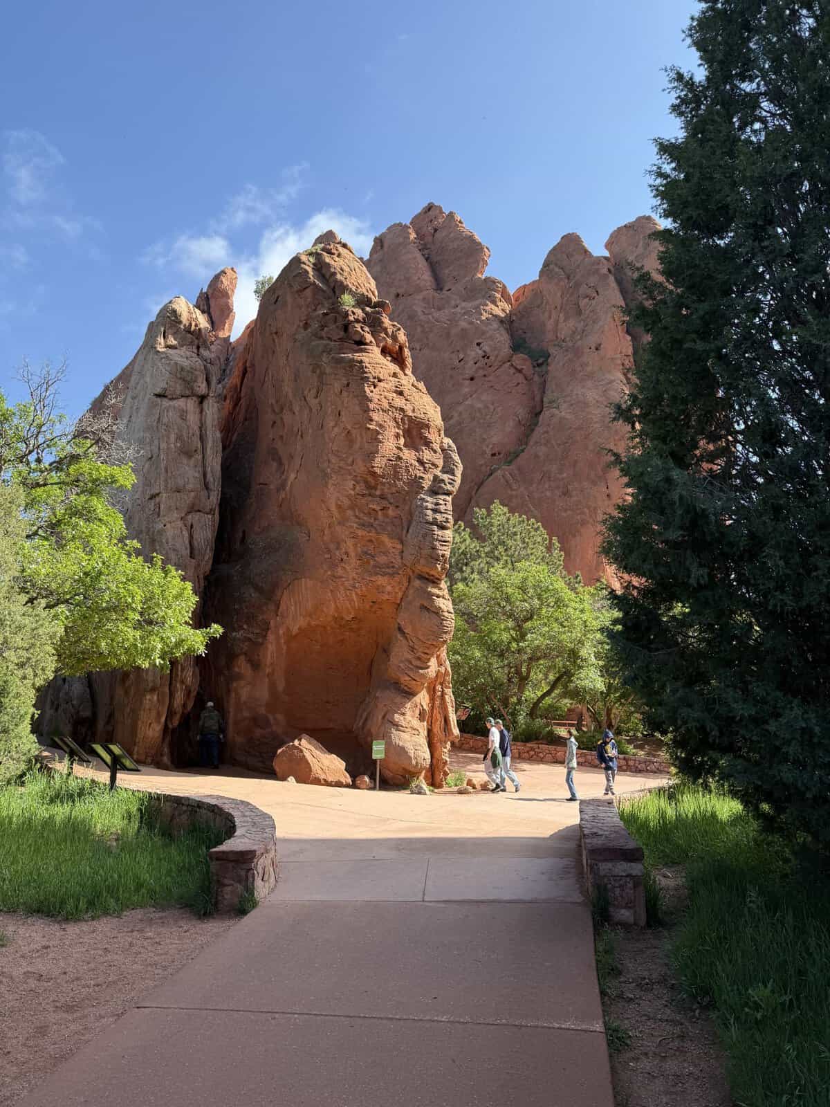 Towering red rock formations along a paved walking path in Garden of the Gods, Colorado Springs.