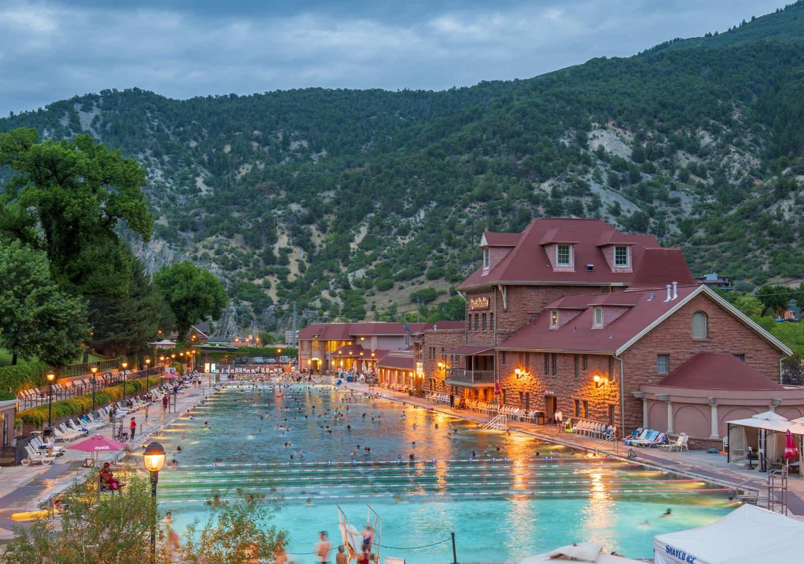 Evening view of Glenwood Hot Springs Pool surrounded by mountains in Glenwood Springs