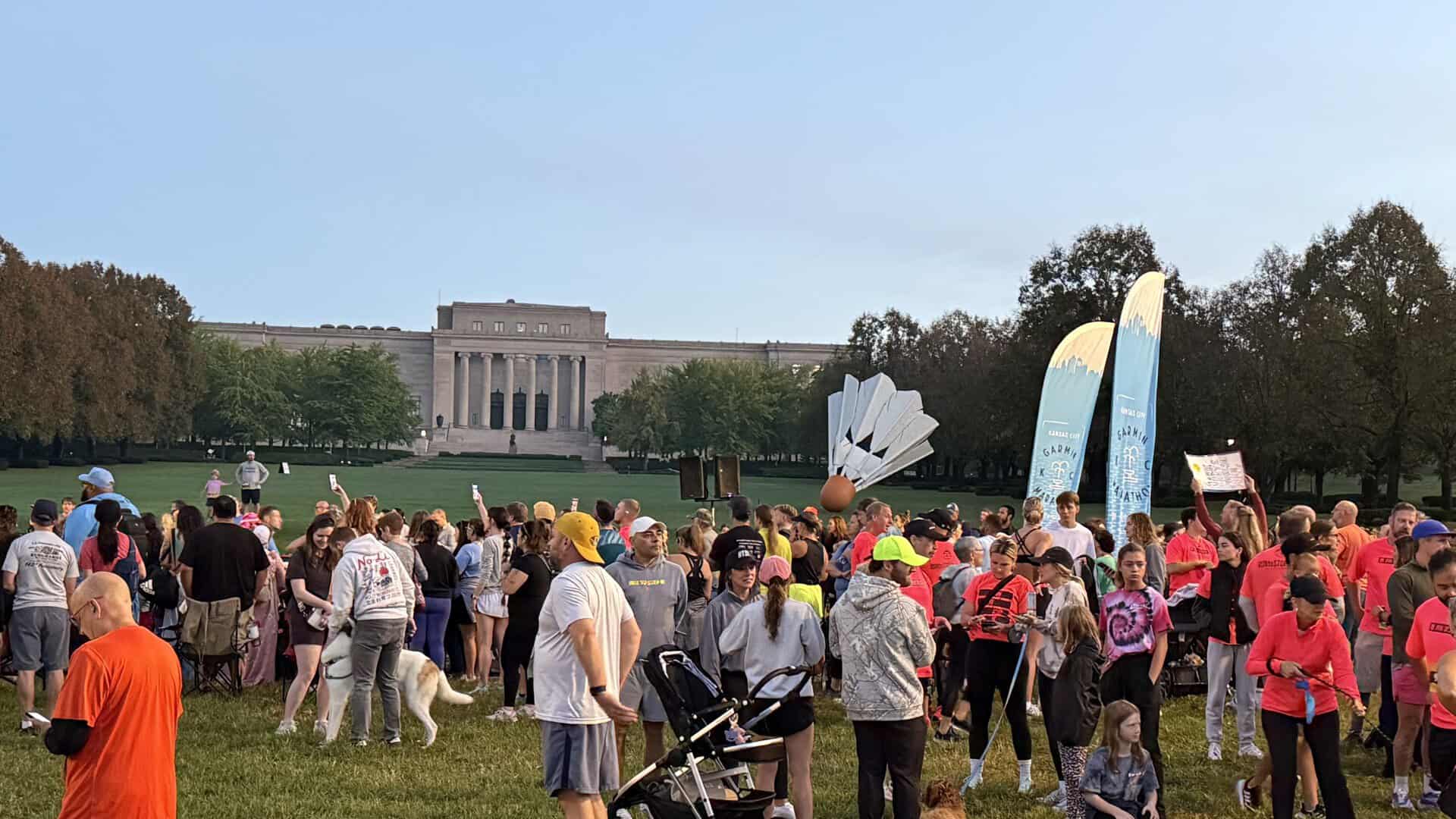 Crowd gathered near the Nelson-Atkins Museum of Art before the Kansas City Marathon with runners, spectators, and Shuttlecock sculpture in the background.