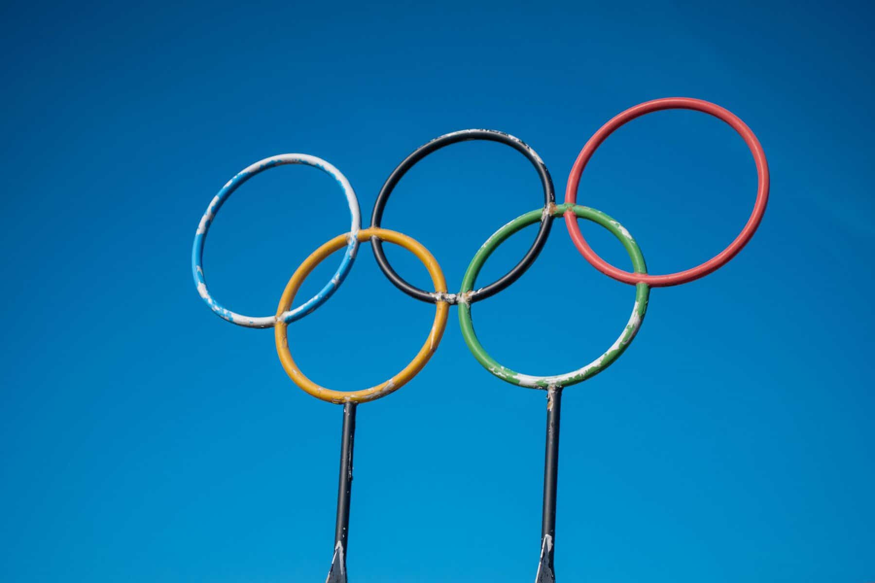Olympic rings sculpture set against a clear blue sky.