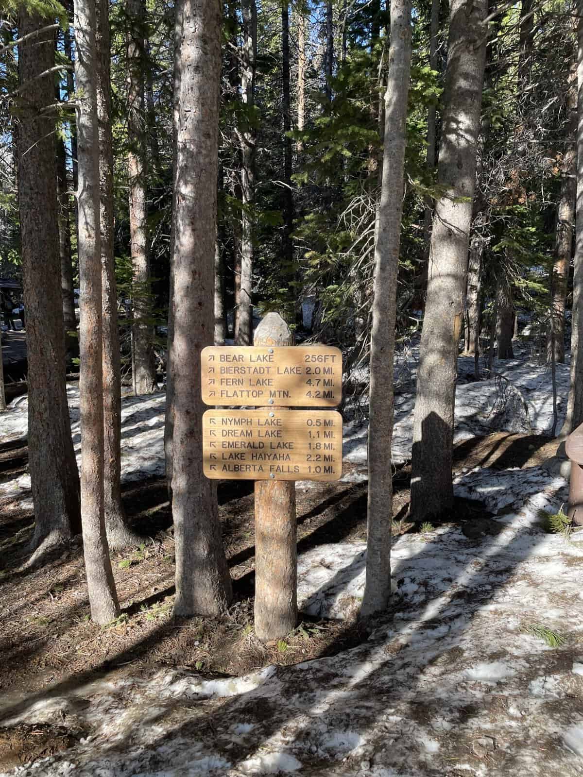 Trail sign showing distances to Bear Lake, Emerald Lake, Dream Lake, and Alberta Falls in Rocky Mountain National Park